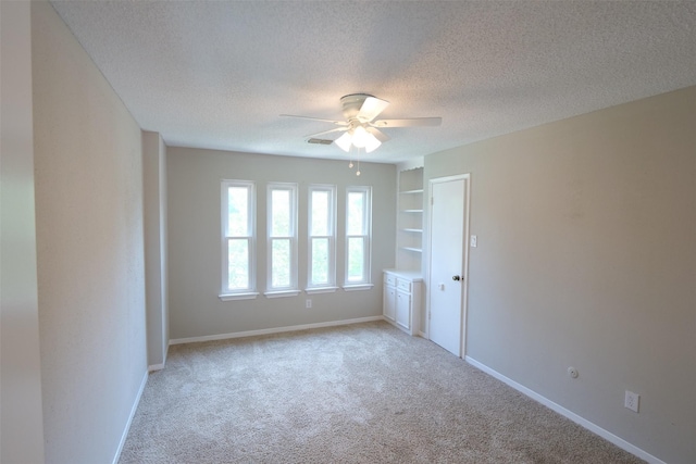 20246 Pittsford Dr, Katy, TX 77450 - unfurnished room with a textured ceiling, ceiling fan, light colored carpet, and built in shelves