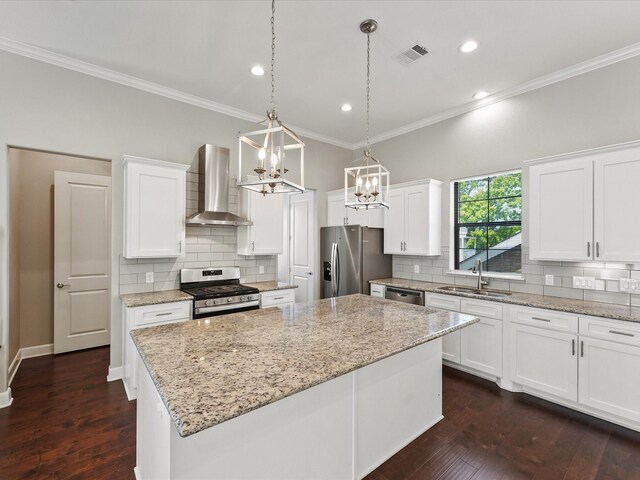 3303 Beverly Forest Dr, Houston, TX 77057 - kitchen featuring wall chimney exhaust hood, stainless steel appliances, ornamental molding, a center island, and a chandelier