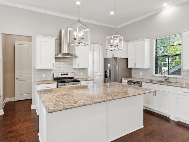 3303 Beverly Forest Dr, Houston, TX 77057 - kitchen featuring stainless steel appliances, wall chimney range hood, a kitchen island, ornamental molding, and white cabinets