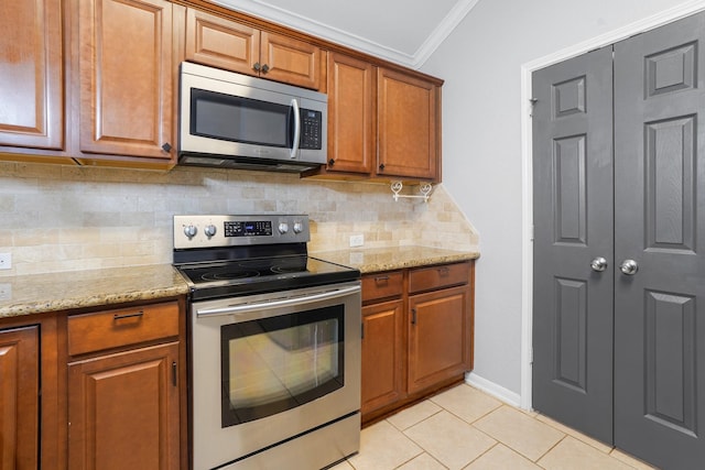 17919 Eagle Pass Falls Ct, Humble, TX 77346 - kitchen with appliances with stainless steel finishes, brown cabinetry, crown molding, light tile patterned flooring, and tasteful backsplash