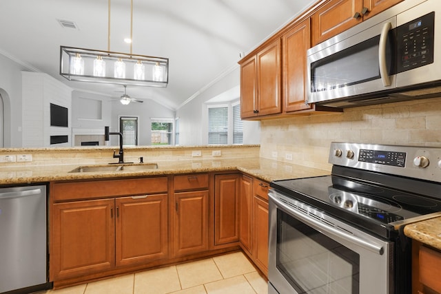 17919 Eagle Pass Falls Ct, Humble, TX 77346 - kitchen with appliances with stainless steel finishes, crown molding, ceiling fan, brown cabinetry, and backsplash
