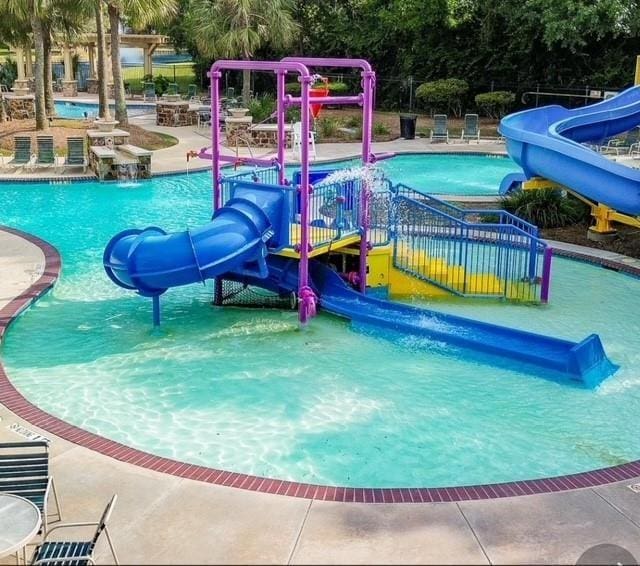 17919 Eagle Pass Falls Ct, Humble, TX 77346 - community pool with a water play area, a water slide, and a patio