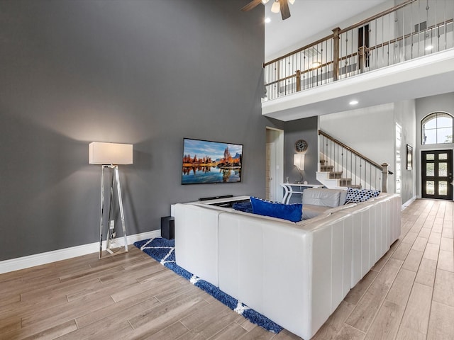 23027 Needlegrass Rd, Katy, TX 77493 - living room featuring a high ceiling, wood finished floors, stairs, a ceiling fan, and recessed lighting