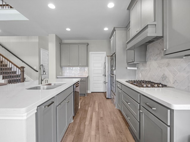 23027 Needlegrass Rd, Katy, TX 77493 - kitchen with gray cabinets, stainless steel appliances, recessed lighting, backsplash, and light wood finished floors
