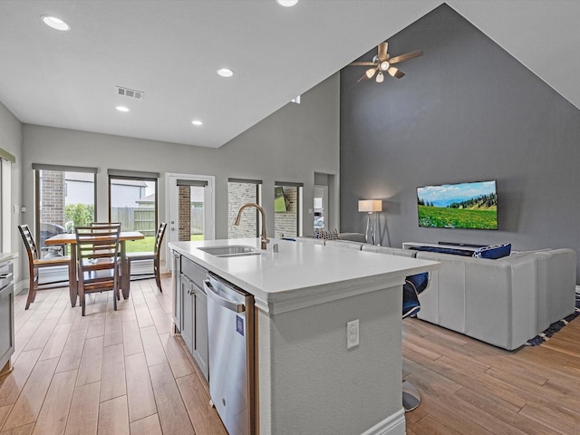 23027 Needlegrass Rd, Katy, TX 77493 - kitchen with stainless steel dishwasher, light wood-style floors, light countertops, open floor plan, and a ceiling fan