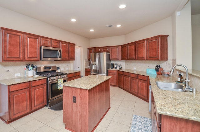 6215 Carnaby Ln, Rosenberg, TX 77471 - kitchen with stainless steel appliances, light stone counters, decorative backsplash, light tile patterned floors, and a kitchen island