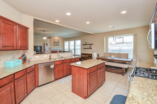 6215 Carnaby Ln, Rosenberg, TX 77471 - kitchen featuring appliances with stainless steel finishes, plenty of natural light, tasteful backsplash, a peninsula, and recessed lighting