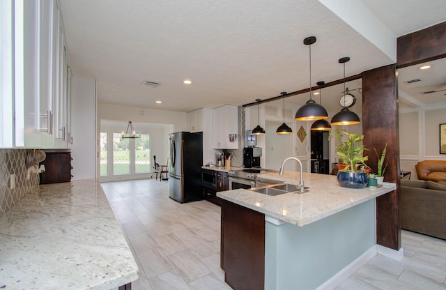 5422 Windy Lake Dr, Houston, TX 77345 - kitchen with appliances with stainless steel finishes, light stone counters, tasteful backsplash, and a peninsula