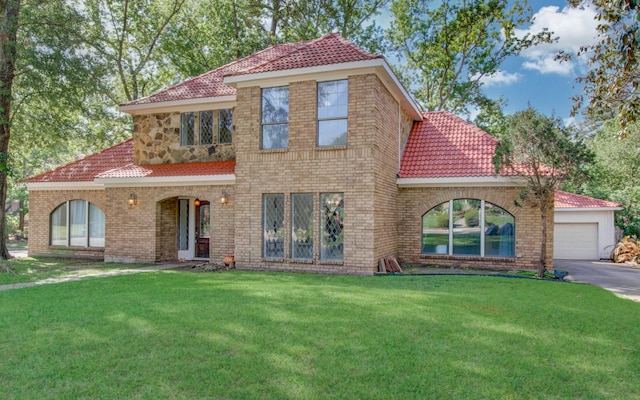 5422 Windy Lake Dr, Houston, TX 77345 - mediterranean / spanish home with a front lawn, asphalt driveway, a tile roof, an attached garage, and brick siding