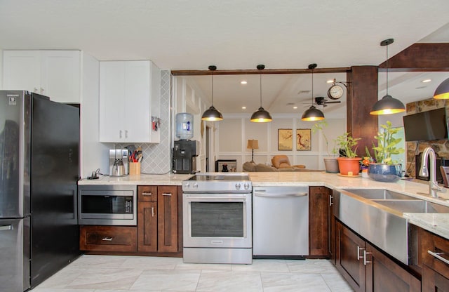 5422 Windy Lake Dr, Houston, TX 77345 - kitchen with stainless steel appliances, tasteful backsplash, light stone counters, white cabinetry, and decorative light fixtures