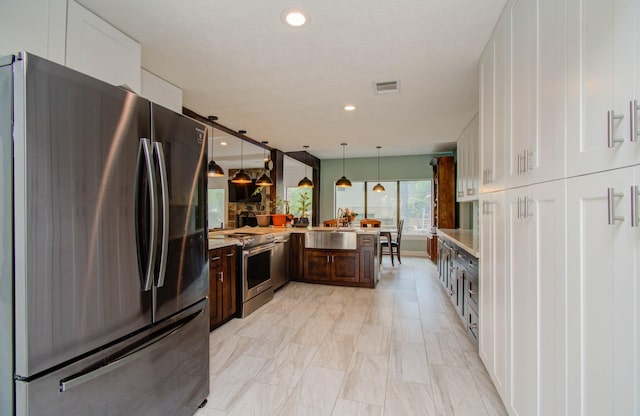 5422 Windy Lake Dr, Houston, TX 77345 - kitchen featuring stainless steel appliances, light countertops, white cabinets, dark brown cabinetry, and recessed lighting
