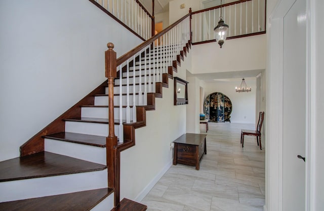 5422 Windy Lake Dr, Houston, TX 77345 - stairs with a chandelier, a towering ceiling, and marble look tile flooring