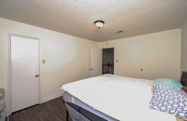 5422 Windy Lake Dr, Houston, TX 77345 - bedroom featuring dark wood-type flooring and a textured ceiling