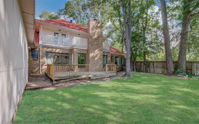 5422 Windy Lake Dr, Houston, TX 77345 - back of house with a balcony, a fenced backyard, a chimney, brick siding, and a tile roof