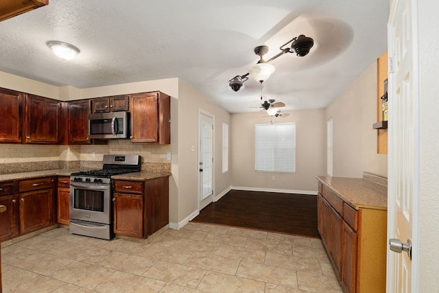 2351 Loyanne Dr, Spring, TX 77373 - kitchen with appliances with stainless steel finishes, backsplash, ceiling fan, light tile patterned floors, and open floor plan