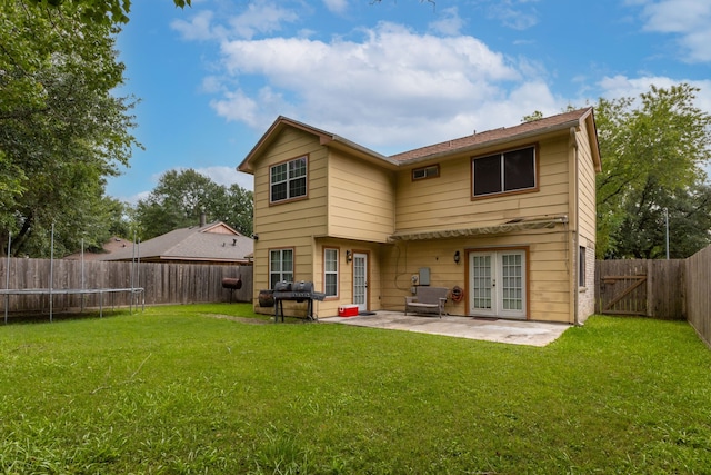 2351 Loyanne Dr, Spring, TX 77373 - back of property featuring french doors, a patio, a fenced backyard, a gate, and a trampoline