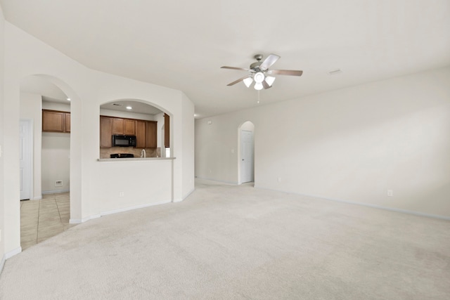 15107 Sequoia Meadow Ct, Humble, TX 77346 - unfurnished living room with arched walkways, light carpet, a ceiling fan, and recessed lighting