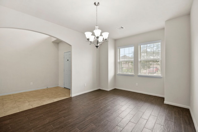 15107 Sequoia Meadow Ct, Humble, TX 77346 - empty room featuring dark wood-type flooring, a chandelier, and arched walkways