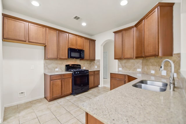 15107 Sequoia Meadow Ct, Humble, TX 77346 - kitchen with black appliances, brown cabinets, arched walkways, tasteful backsplash, and recessed lighting