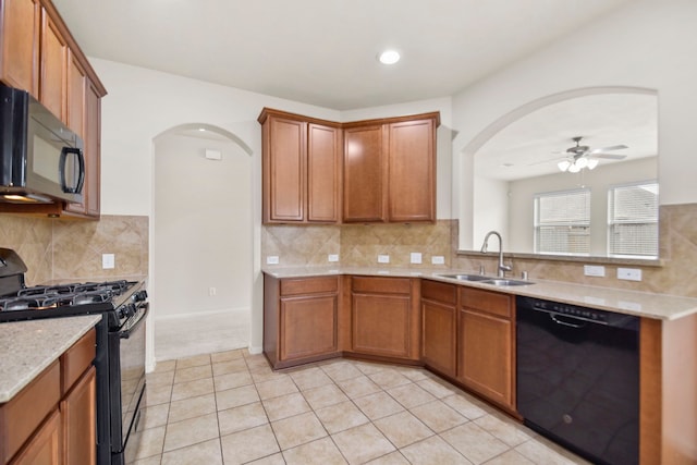 15107 Sequoia Meadow Ct, Humble, TX 77346 - kitchen with black appliances, arched walkways, ceiling fan, tasteful backsplash, and brown cabinets