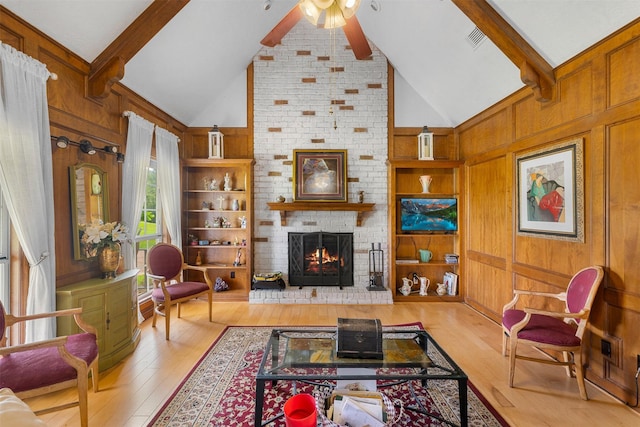 3357 Tamy Ln, Brenham, TX 77833 - living area with a fireplace, a ceiling fan, beamed ceiling, wood-type flooring, and wood walls
