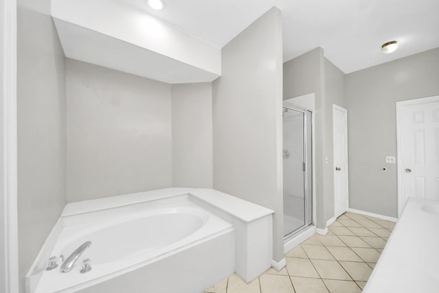 9410 Gatmere Ct, Sugar Land, TX 77498 - bathroom featuring a bath, a stall shower, and tile patterned flooring