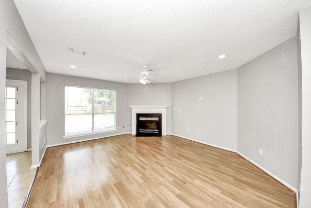 9410 Gatmere Ct, Sugar Land, TX 77498 - unfurnished living room with ceiling fan, a fireplace with flush hearth, light wood-style floors, and recessed lighting