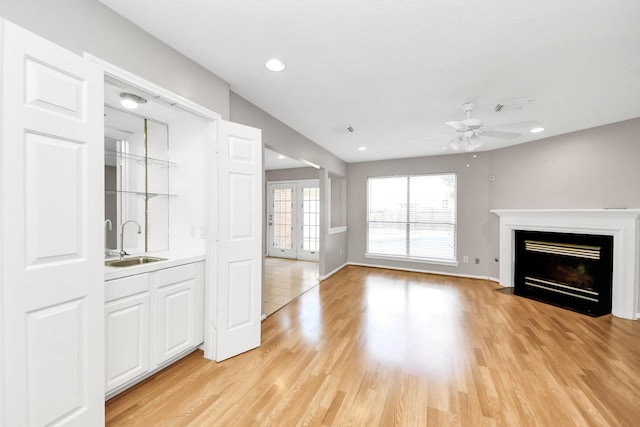 9410 Gatmere Ct, Sugar Land, TX 77498 - unfurnished living room featuring a ceiling fan, a fireplace with flush hearth, recessed lighting, and light wood-style floors