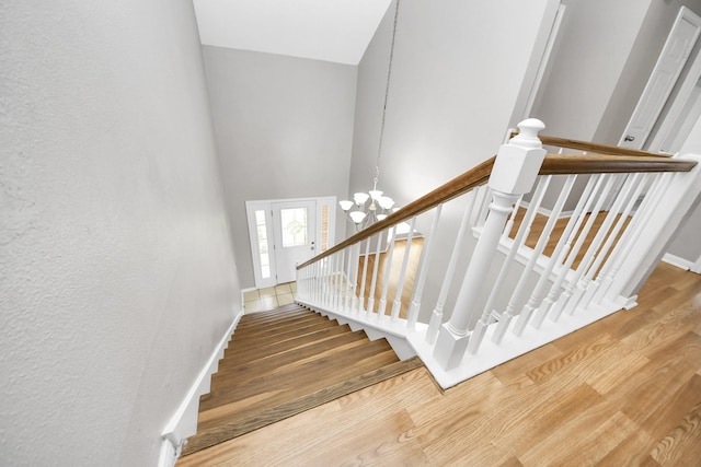 9410 Gatmere Ct, Sugar Land, TX 77498 - stairway with wood finished floors, a towering ceiling, and a chandelier