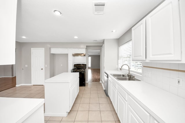9410 Gatmere Ct, Sugar Land, TX 77498 - kitchen with black gas stove, decorative backsplash, under cabinet range hood, light countertops, and recessed lighting