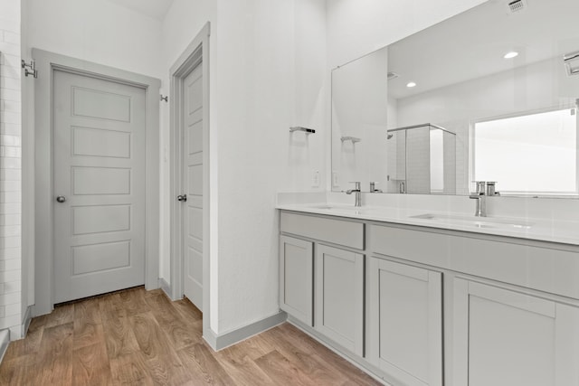 207 William Ln, Rosharon, TX 77583 - bathroom featuring a stall shower, wood finished floors, double vanity, and recessed lighting