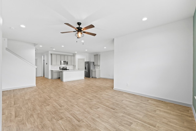207 William Ln, Rosharon, TX 77583 - unfurnished living room featuring a ceiling fan, recessed lighting, light wood-style flooring, and stairs