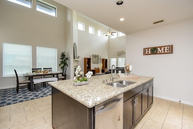 4615 Montcliff Bend Ln, Sugar Land, TX 77479 - kitchen with stainless steel dishwasher, a ceiling fan, light tile patterned flooring, a kitchen island with sink, and a towering ceiling