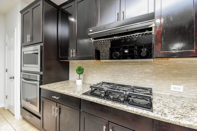 4615 Montcliff Bend Ln, Sugar Land, TX 77479 - kitchen featuring appliances with stainless steel finishes, decorative backsplash, light stone counters, and light tile patterned floors