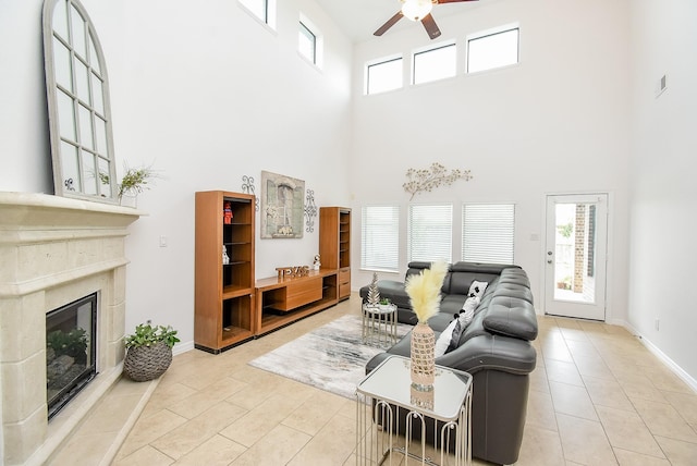 4615 Montcliff Bend Ln, Sugar Land, TX 77479 - living area with a towering ceiling, ceiling fan, a high end fireplace, and light tile patterned floors