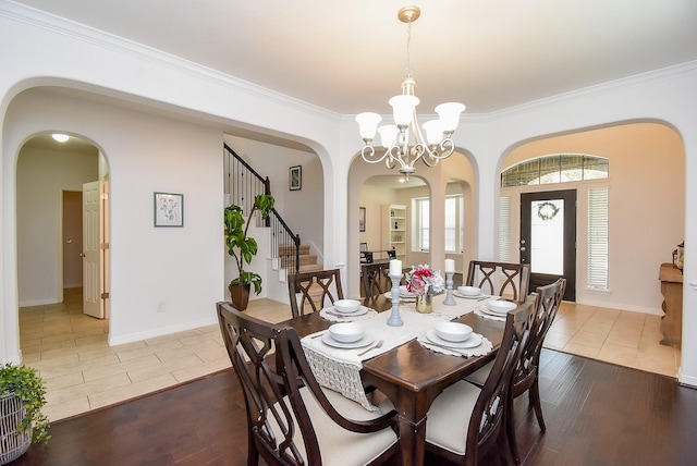 4615 Montcliff Bend Ln, Sugar Land, TX 77479 - dining room featuring arched walkways, a chandelier, hardwood / wood-style floors, crown molding, and stairs