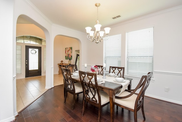 4615 Montcliff Bend Ln, Sugar Land, TX 77479 - dining area featuring arched walkways, a chandelier, crown molding, and wood finished floors