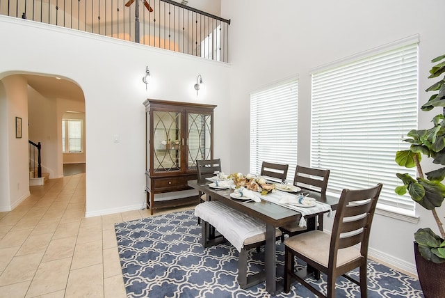 4615 Montcliff Bend Ln, Sugar Land, TX 77479 - dining room featuring a high ceiling, arched walkways, light tile patterned floors, and stairs