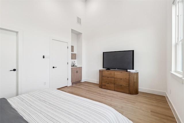 612 Hughes St Unit A, Houston, TX 77023 - bedroom featuring light wood-type flooring and a towering ceiling