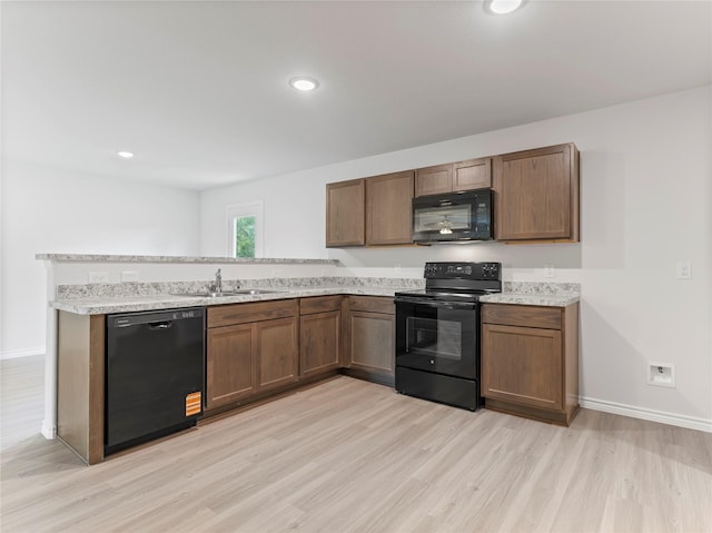 312 N Orange St, Sweeny, TX 77480 - kitchen with black appliances, light wood-type flooring, a peninsula, and recessed lighting