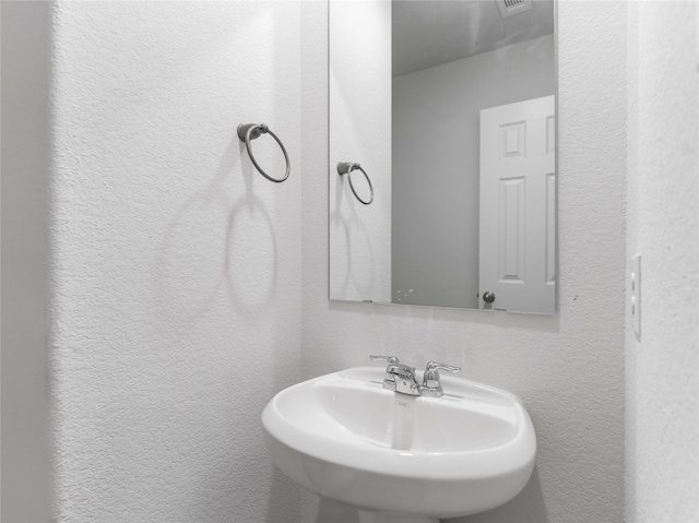 312 N Orange St, Sweeny, TX 77480 - bathroom featuring a sink and a textured wall
