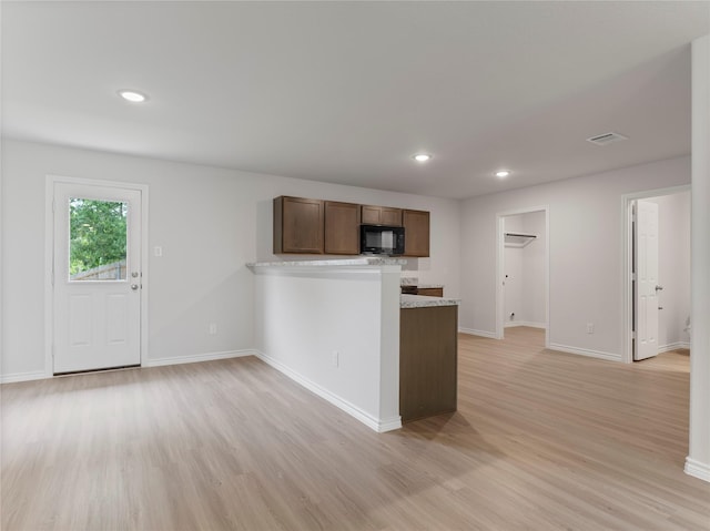 312 N Orange St, Sweeny, TX 77480 - kitchen with black microwave, light wood-type flooring, a peninsula, light countertops, and recessed lighting