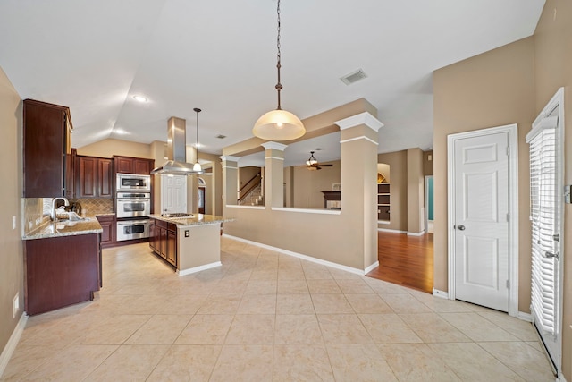 15015 Cozy Hollow Ln, Houston, TX 77044 - kitchen featuring ornate columns, island range hood, appliances with stainless steel finishes, decorative backsplash, and ceiling fan