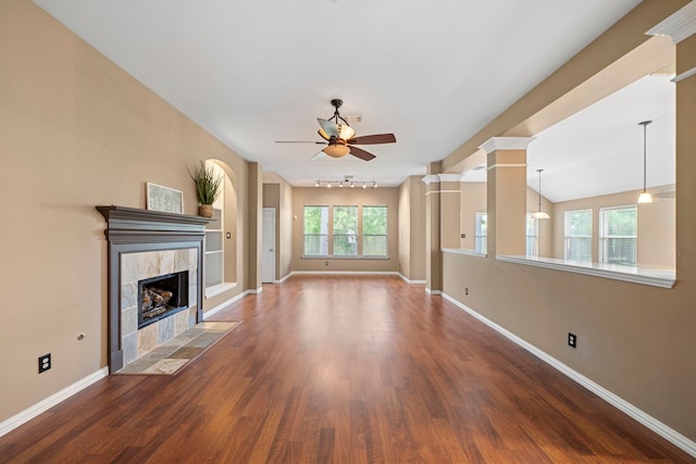 15015 Cozy Hollow Ln, Houston, TX 77044 - unfurnished living room with ceiling fan, a fireplace, wood finished floors, and ornate columns