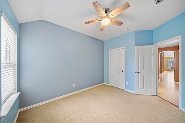 15015 Cozy Hollow Ln, Houston, TX 77044 - unfurnished bedroom featuring arched walkways, carpet, multiple windows, a ceiling fan, and lofted ceiling