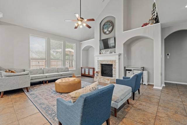14402 Hazeldale Dr, Cypress, TX 77429 - living room with a ceiling fan, a glass covered fireplace, arched walkways, high vaulted ceiling, and stone tile flooring