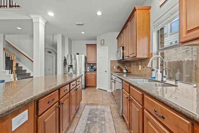 14402 Hazeldale Dr, Cypress, TX 77429 - kitchen with stainless steel appliances, brown cabinets, stone counters, tasteful backsplash, and recessed lighting