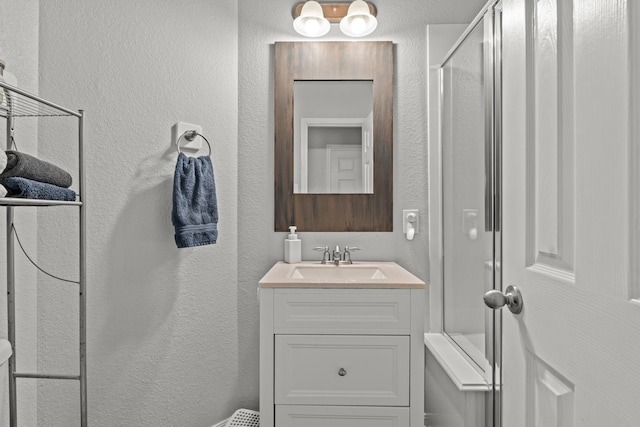 14402 Hazeldale Dr, Cypress, TX 77429 - bathroom featuring vanity, a shower with shower door, and a textured wall