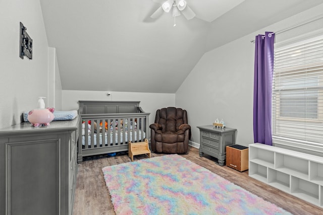14402 Hazeldale Dr, Cypress, TX 77429 - bedroom featuring lofted ceiling, wood finished floors, a nursery area, and a ceiling fan