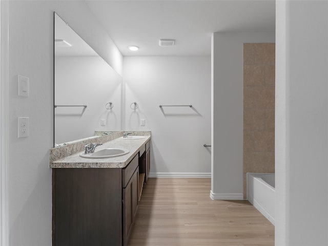306 N Orange St, Sweeny, TX 77480 - bathroom featuring double vanity, wood finished floors, and washtub / shower combination